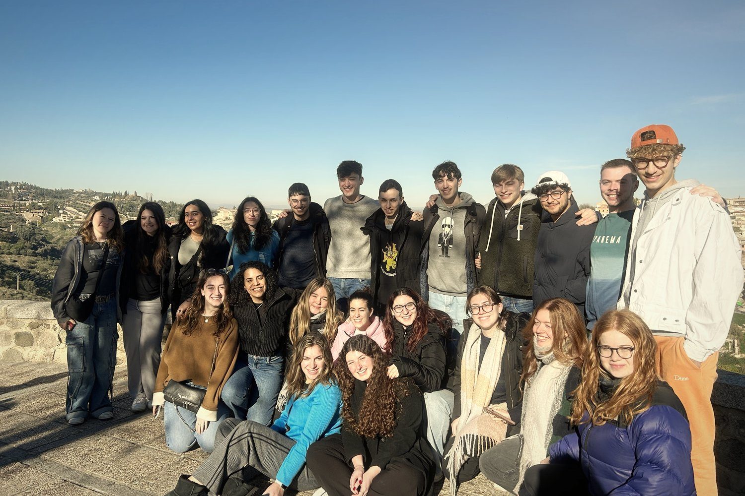 A group of young travellers at a viewpoint on a sunny day