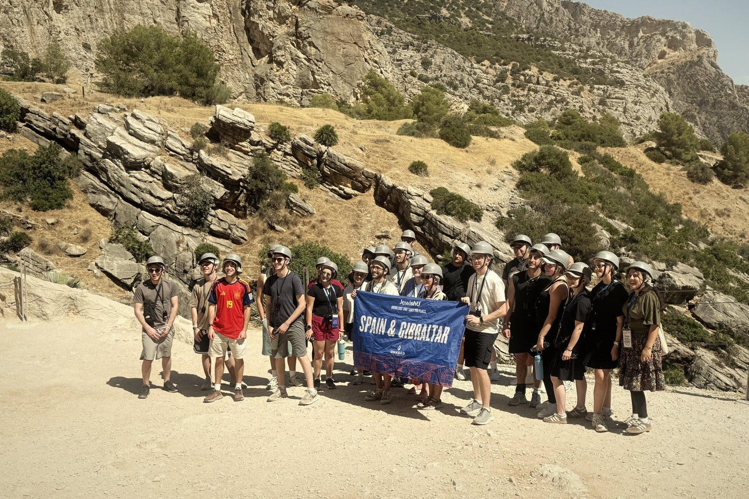 A student group with helmets and a Spain & Gibraltar banner at the Caminito del Rey