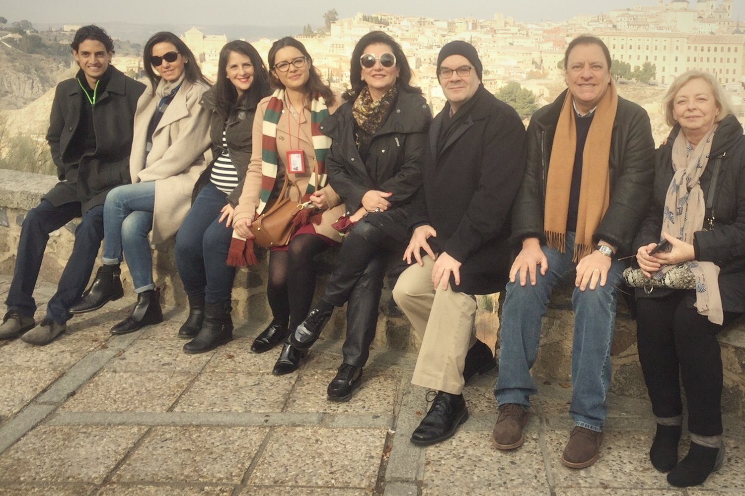 A group seated at a viewpoint over Toledo