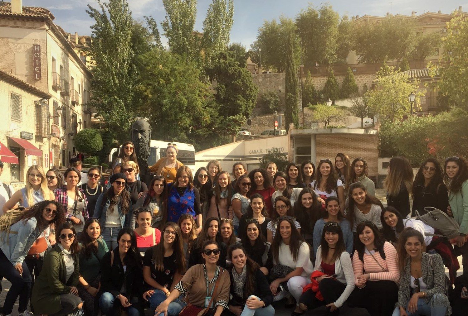 A large group of young travellers in Toledo, bathed in golden light