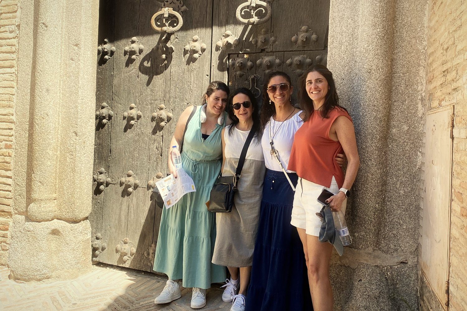 Four friends at an old studded door in Toledo