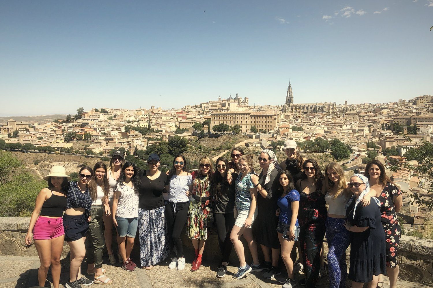A group of young women in front of the Toledo skyline
