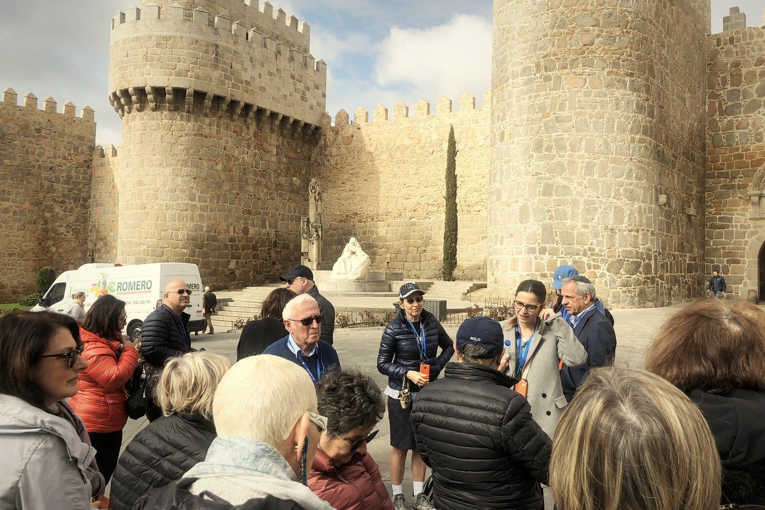 A group listening to their guide below the walls of Ávila